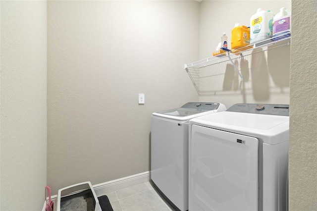 clothes washing area with washer and clothes dryer and light tile patterned floors