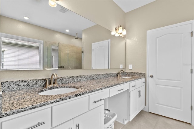 bathroom featuring tile patterned floors, a shower with door, and vanity