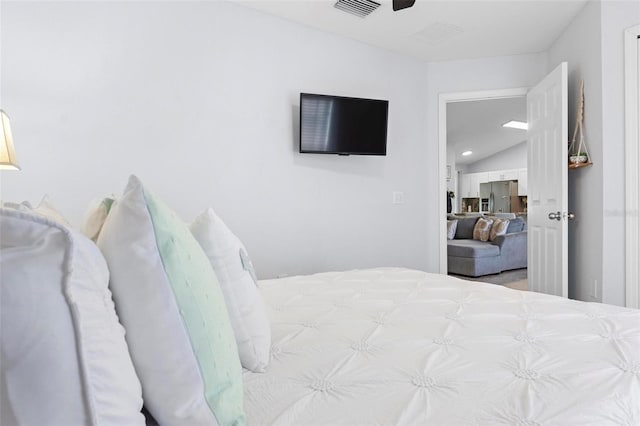 bedroom with vaulted ceiling and stainless steel fridge with ice dispenser