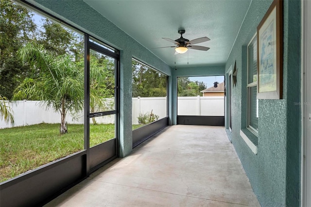 unfurnished sunroom with ceiling fan