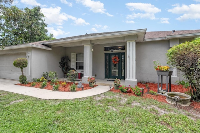 4609 Indian River Dr, Cocoa, FL 32927 - view of exterior entry with a garage, a lawn, a porch, and stucco siding