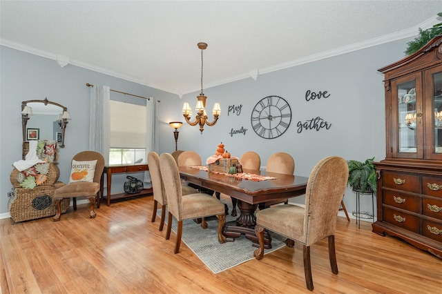 dining room featuring ornamental molding, a notable chandelier, and light hardwood / wood-style floors