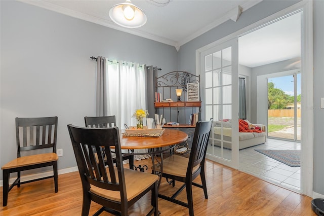 dining area featuring light hardwood / wood-style flooring and ornamental molding