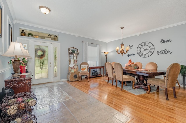 dining room featuring a notable chandelier, light hardwood / wood-style flooring, and crown molding