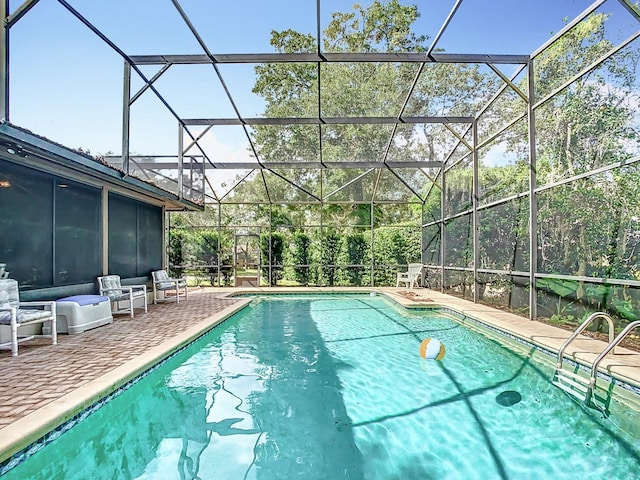 view of pool with a patio area and glass enclosure