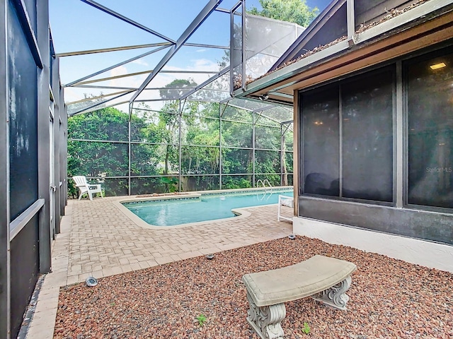 view of swimming pool with a patio and a lanai