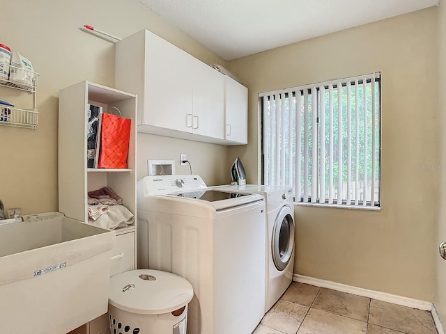 washroom featuring cabinets, light tile patterned flooring, sink, and washing machine and dryer