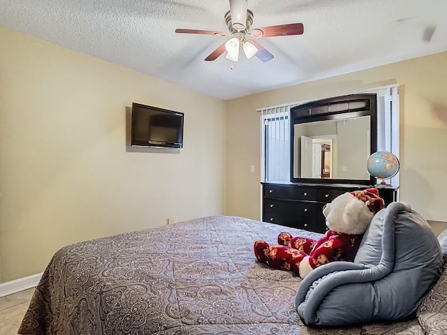 tiled bedroom featuring a textured ceiling and ceiling fan