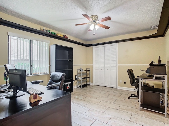 home office with a textured ceiling and ceiling fan