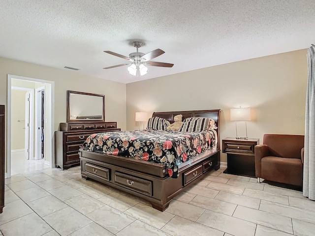 tiled bedroom featuring a textured ceiling and ceiling fan