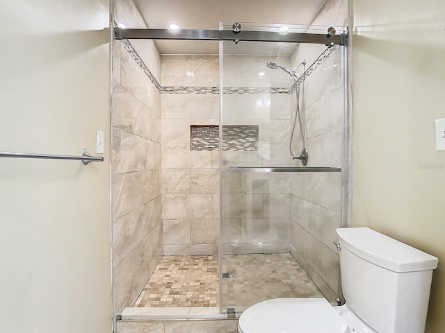 bathroom featuring toilet and an enclosed shower