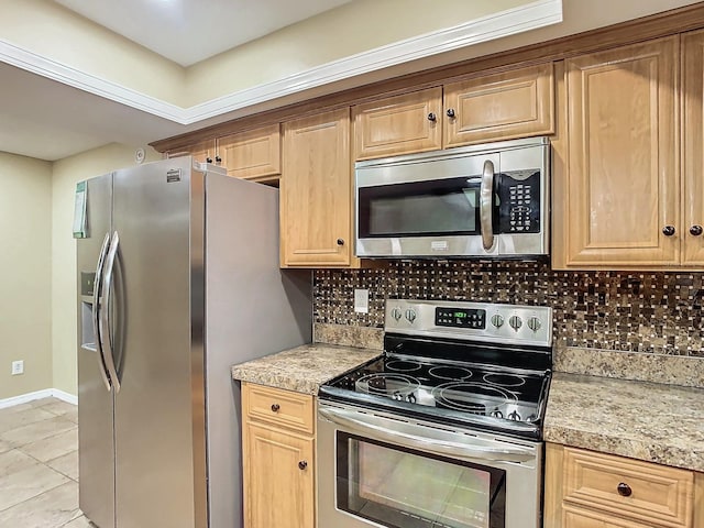 kitchen with appliances with stainless steel finishes, light tile patterned floors, and backsplash