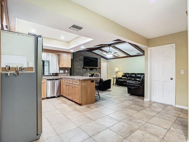 kitchen with kitchen peninsula, lofted ceiling, ceiling fan, appliances with stainless steel finishes, and a breakfast bar area