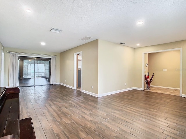 empty room featuring a textured ceiling and hardwood / wood-style flooring