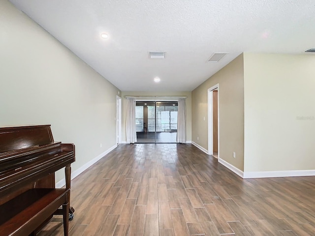 empty room with a textured ceiling and hardwood / wood-style flooring