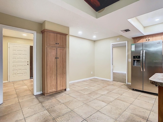 kitchen featuring light tile patterned floors and stainless steel fridge with ice dispenser