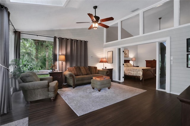 living room with dark wood-type flooring, ceiling fan, high vaulted ceiling, and wood walls