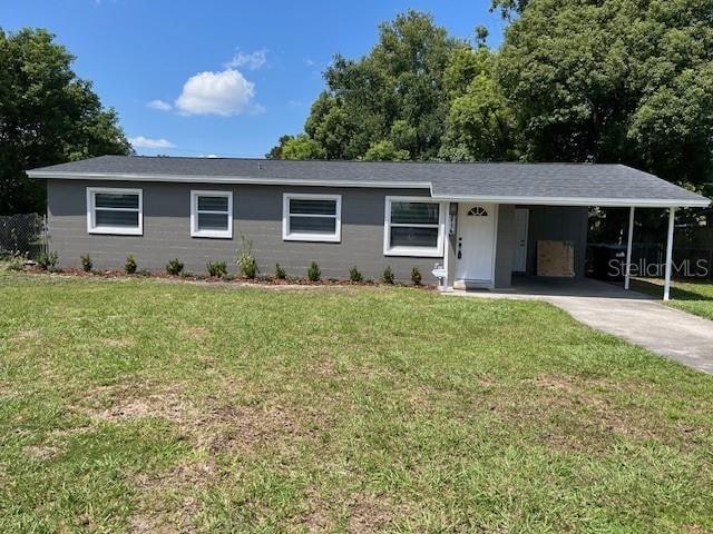 ranch-style home with a front lawn and a carport