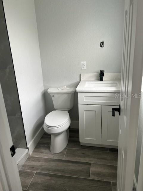 bathroom with vanity, hardwood / wood-style floors, and toilet