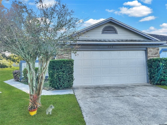 view of front of property with a garage and a front lawn