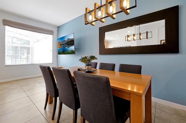 dining area featuring light tile patterned flooring and a notable chandelier