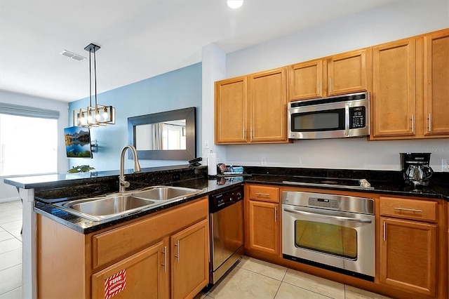 kitchen featuring dark stone counters, light tile patterned flooring, sink, and stainless steel appliances