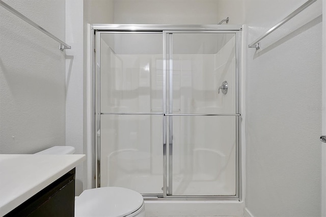 bathroom with vanity, toilet, and a shower with shower door