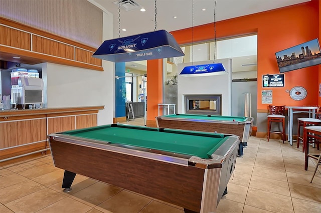 recreation room featuring a multi sided fireplace, pool table, and light tile patterned floors