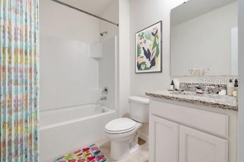 full bathroom featuring shower / bath combo with shower curtain, vanity, and toilet