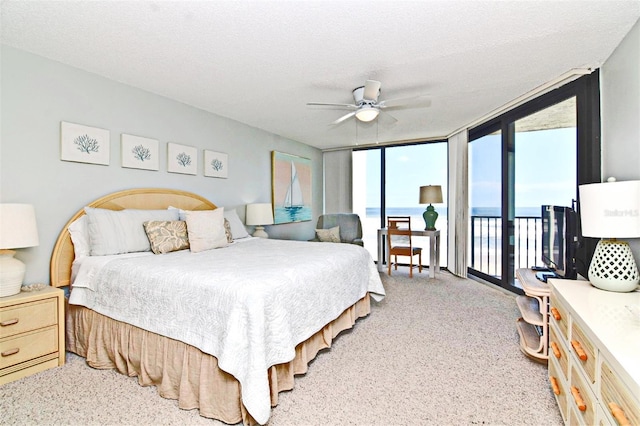 bedroom featuring a textured ceiling, ceiling fan, access to outside, floor to ceiling windows, and carpet