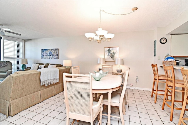 dining space with ceiling fan with notable chandelier, a textured ceiling, and light tile patterned flooring