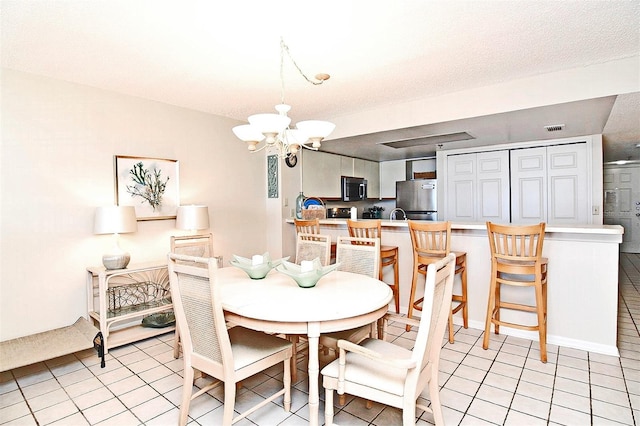 dining space featuring visible vents, a notable chandelier, and light tile patterned floors