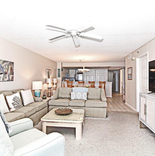 living room featuring light colored carpet, a textured ceiling, and ceiling fan with notable chandelier