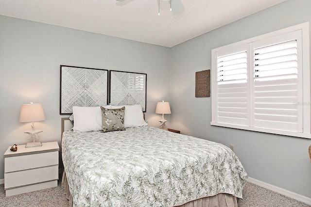 carpeted bedroom featuring ceiling fan and baseboards