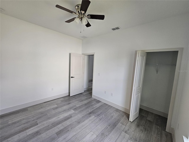 unfurnished bedroom featuring light hardwood / wood-style flooring, a closet, and ceiling fan