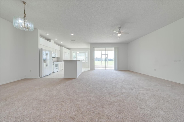 unfurnished living room with ceiling fan with notable chandelier, a textured ceiling, and light colored carpet