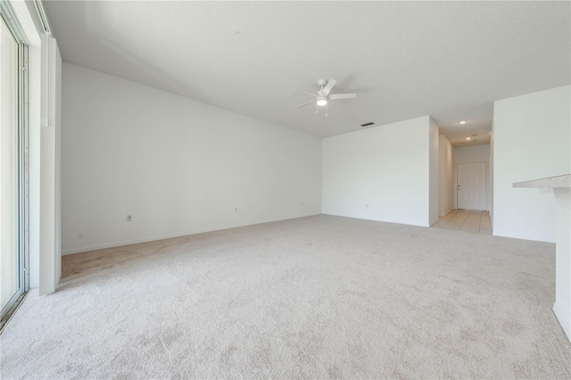 carpeted empty room featuring a textured ceiling and ceiling fan