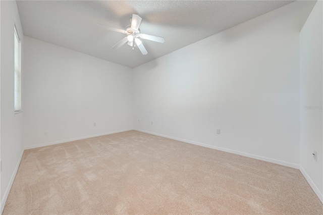 carpeted spare room featuring ceiling fan and a textured ceiling