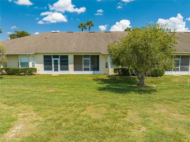 back of house featuring a yard and a sunroom