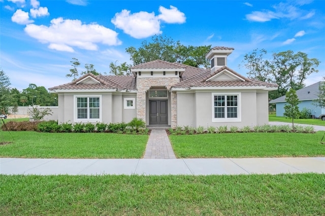 mediterranean / spanish house featuring a front yard