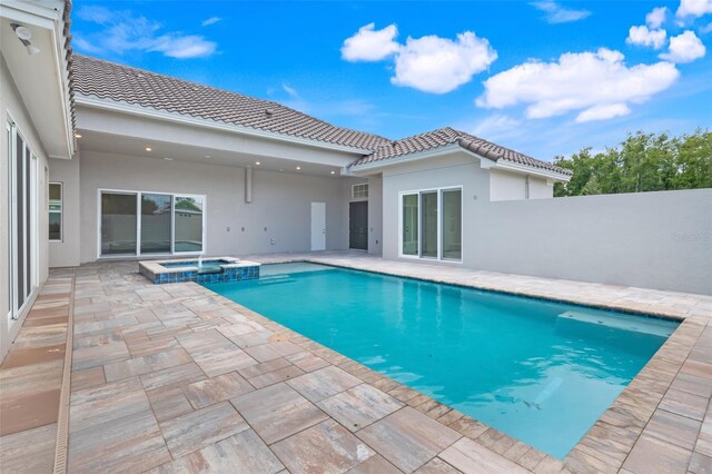 view of swimming pool featuring an in ground hot tub and a patio