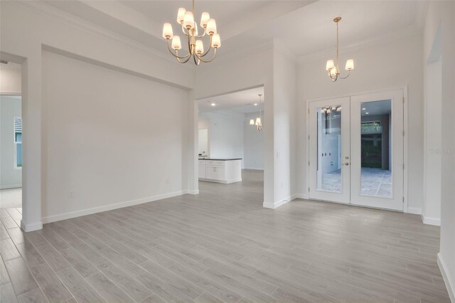 interior space featuring french doors, a notable chandelier, crown molding, and light hardwood / wood-style floors