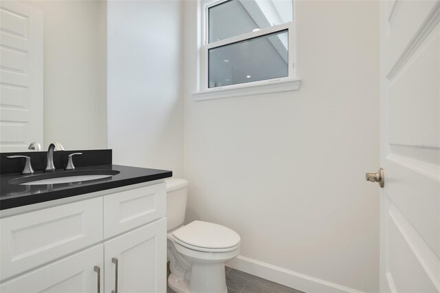 bathroom with wood-type flooring, vanity, and toilet