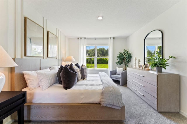 bedroom featuring a textured ceiling and light colored carpet