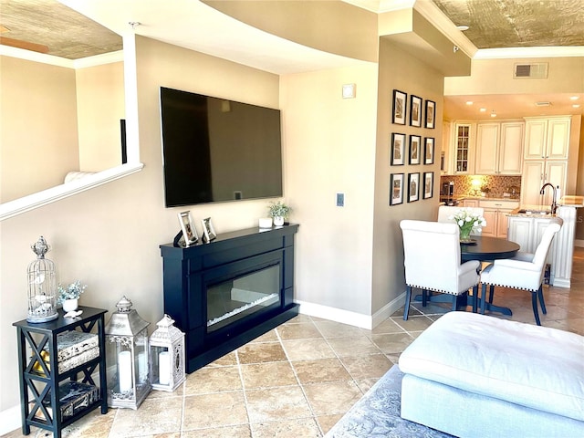 living room featuring ornamental molding and sink