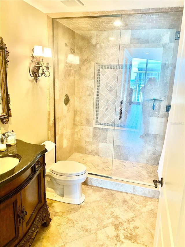 bathroom featuring vanity, toilet, and a shower with shower door