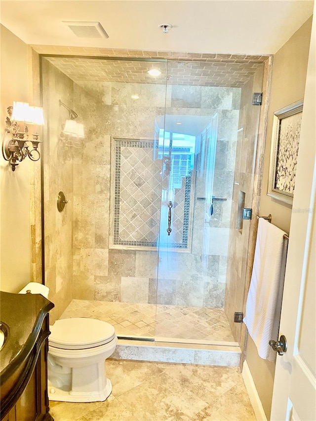 bathroom featuring tile patterned flooring, walk in shower, vanity, and toilet