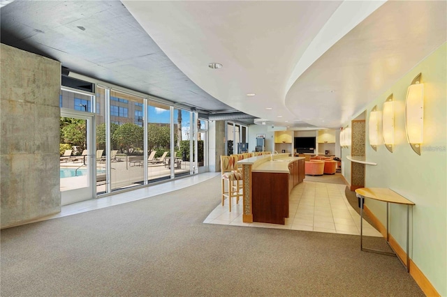 155 S Court Ave Unit 2710, Orlando, FL 32801 - kitchen with open floor plan, healthy amount of natural light, light carpet, a spacious island, and a wall of windows