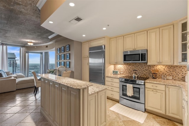 155 S Court Ave Unit 2710, Orlando, FL 32801 - kitchen featuring stainless steel appliances, cream cabinetry, open floor plan, a kitchen island, and recessed lighting