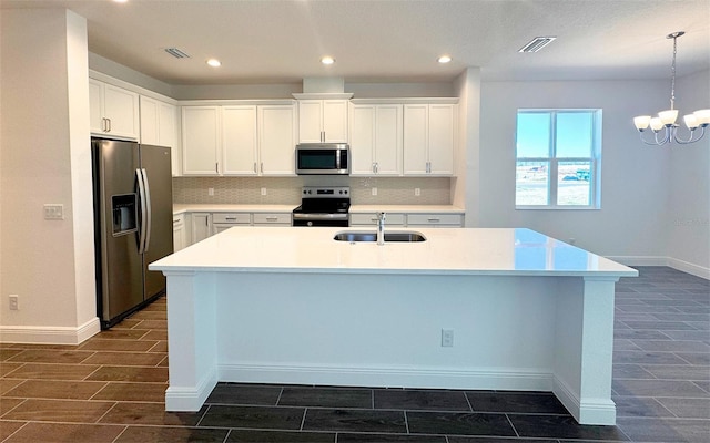 kitchen with visible vents, stainless steel appliances, wood finish floors, and a sink